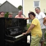 Uschi Bauer gibt Klavierkonzert im Garten. Zuvor "durften" die Freunde aber erst ein Mal das Klavier transportieren.